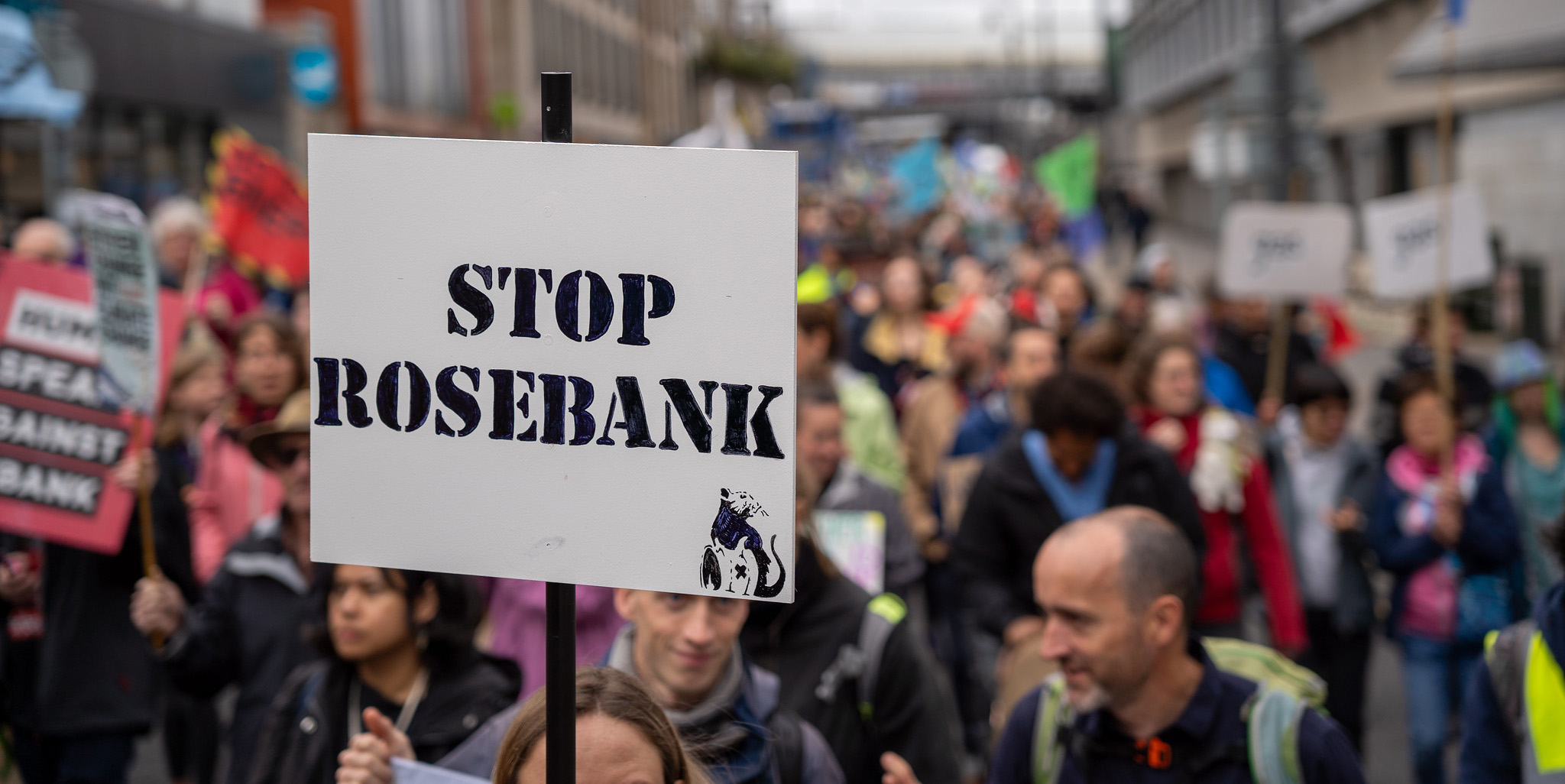 A Stop Rosebank sign help up during a climate march A Stop Rosebank sign help up during a climate march